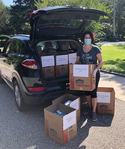 Christina Bosco loads enrichment boxes into her car for delivery to senior centers.